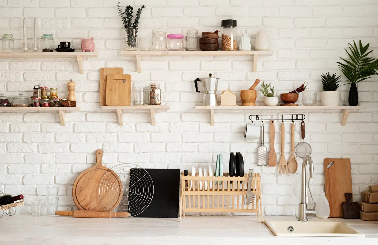 A stylish collection of kitchen accessories, featuring sleek utensils, cutting boards, stainless steel measuring cups, colorful silicone spatulas, and elegant storage jars arranged on a modern kitchen countertop.