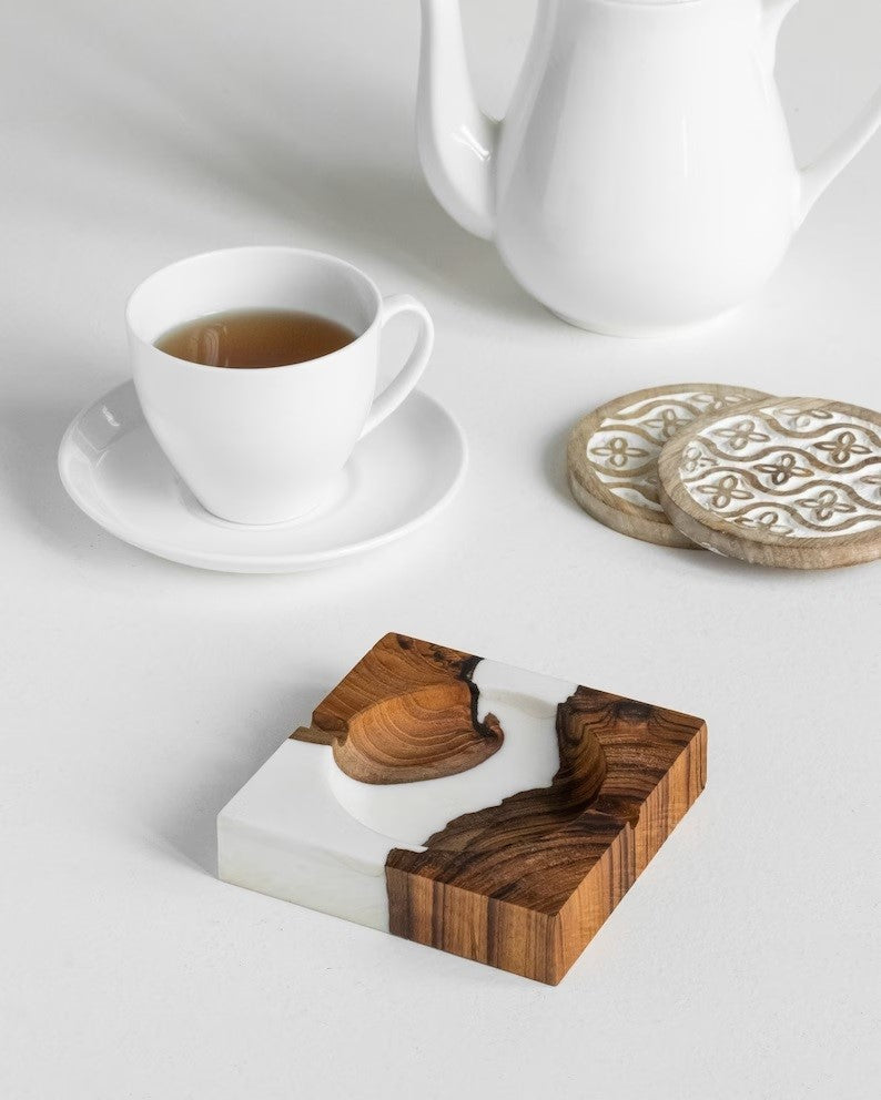 A modern ashtray made of glass, metal, or ceramic, featuring a sleek design with a shallow bowl and cigarette rests. It is placed on a surface to showcase its functionality and stylish appearance for containing ashes and cigarette butts