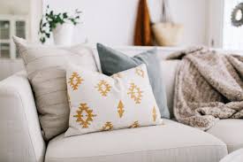 A selection of decorative pillows with various textures, colors, and patterns, arranged on a sofa or bed. The pillows include options like plush throw pillows, patterned cushions, and solid-colored accent pillows, adding comfort and style to the space.