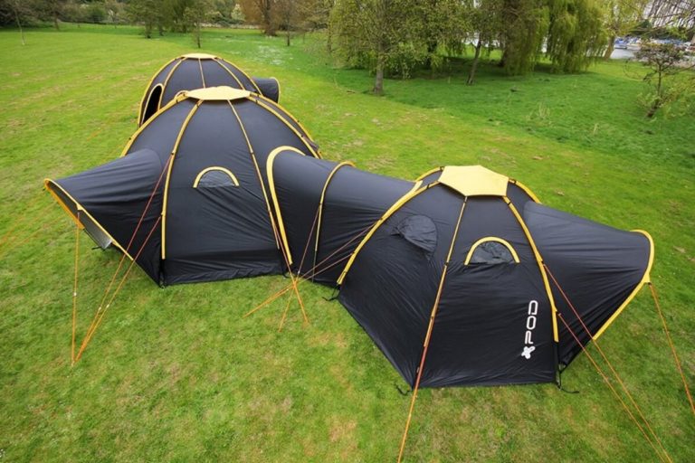 A durable camping tent set up in an outdoor setting, featuring a weather-resistant canopy, spacious interior, and mesh windows for ventilation. 